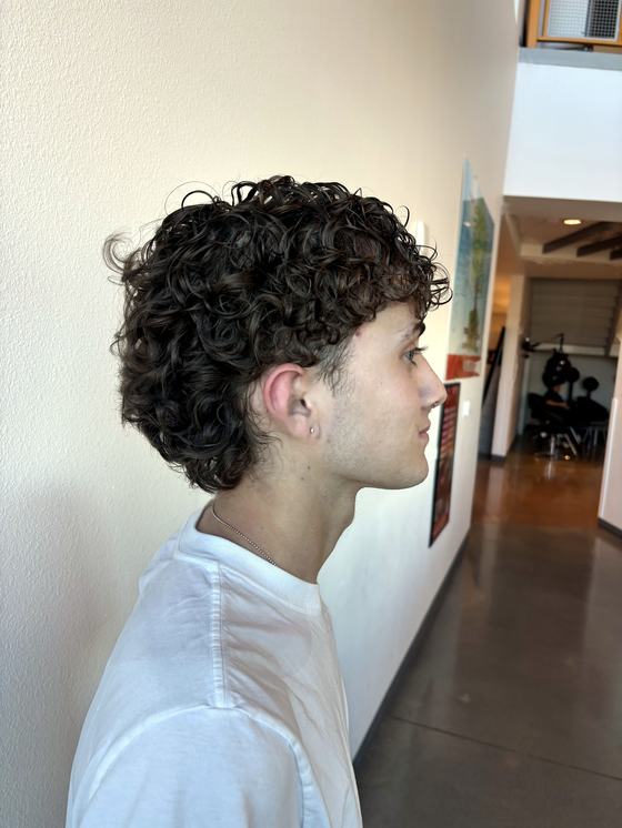 Curly perm on short dark hair, profile view, by Leila Lee
